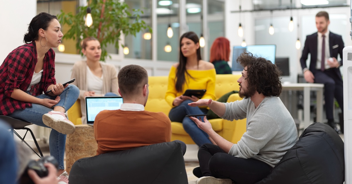 A group of employees has an informal meeting in an open office space